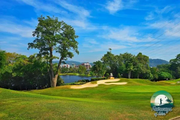 Phuket Country Club golf course with lake, bunkers, and mountain backdrop in Phuket, Thailand