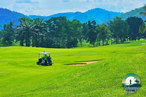 Wide fairway at Majestic Creek Country Club with golf cart and rolling hills in the background